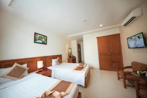 a hotel room with two beds and a table at Valentine Boutique hotel - 29 Bui Vien street in Ho Chi Minh City