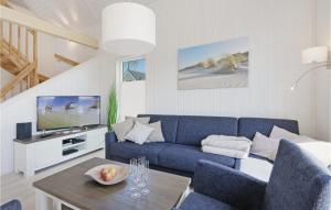 uma sala de estar com um sofá azul e uma televisão em Gorgeous Home In Ostseeresort Olpenitz With Wifi em Olpenitz