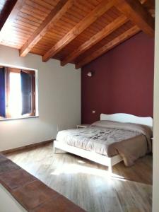 1 dormitorio con 1 cama en una habitación con techos de madera en Ai doganieri, en Randazzo