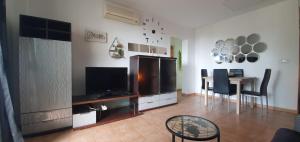 a living room with a television and a table with chairs at el toro in Finestrat