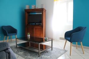 een woonkamer met een tv en 2 stoelen bij Maison de 3 chambres avec jardin clos et wifi a Vasles in Vasles