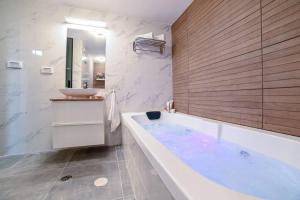 a bathroom with a large tub and a sink at לופט הגליל- דירת סטודיו במרכז העיר טבריה in Tiberias