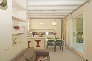 Una sala de estar y una cocina con un sofá y una mesa. en Giulia Luxury Apartment, en Sirmione