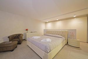 Un dormitorio con una cama grande y una silla. en Giulia Luxury Apartment, en Sirmione 72 fotos más