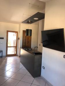 kuchnia z blatem z telewizorem na ścianie w obiekcie La Villa dell Artista con vista mare e dune - IUN Q7440 w mieście Torre dei Corsari