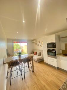 cocina y sala de estar con mesa y sillas en Superbe appartement avec piscine, en Carqueiranne