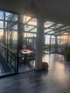 a patio with tables and chairs on a building with windows at Mana-Mana in Grigoleti