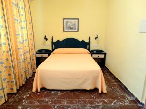 a bedroom with a bed with two night stands at Pension Rural La Fonda in Dúrcal
