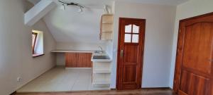 a kitchen with a sink and a wooden door at Prywatny pokój z kuchnią i łazienką in Mszana Dolna