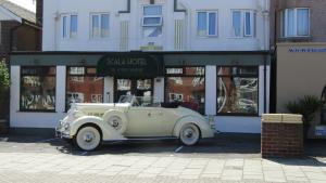 an old white car parked in front of a building at The Scala Hotel in Blackpool
