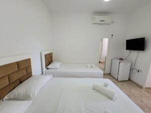 a bedroom with two beds and a tv in it at Vila Geri in Ksamil