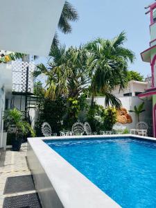 uma piscina em frente a um edifício com palmeiras em The Quetzal em Cancún