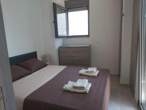 a bedroom with a bed with two towels on it at Villa Maria Sea View by Estia in Balíon