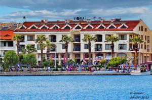 un gran hotel con palmeras frente al agua en Fora Apart Hotel, en Datça