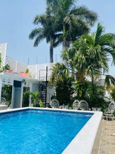 uma piscina em frente a uma casa com palmeiras em The Quetzal em Cancún