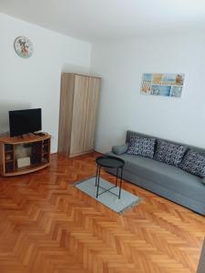 a living room with a couch and a television at App Dalia Losinj in Mali Lošinj