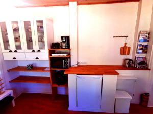 a kitchen with white cabinets and a wooden counter top at The FIG Studio - "Den Gule Svane" Guest House - near Rønne & Beach in Rønne