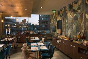un restaurante con mesas y sillas y un bar en Novotel Vina del Mar en Viña del Mar