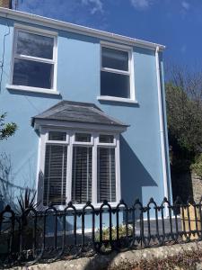 een blauw huis met een hek ervoor bij Hobbes Cottage, pets allowed in Tenby +32 foto's