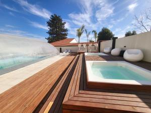 una piscina con bañera de hidromasaje en una terraza de madera en Hotel Astoria by CPH en Villa Carlos Paz