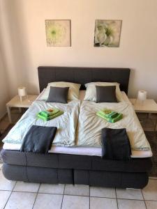 Una cama con dos zapatillas verdes encima. en Ferienwohnung Lutz, en Ascheberg