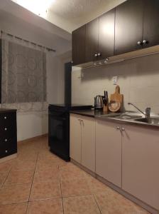 una cocina con armarios blancos y un aparato negro en Apartment Maja, en Lovran