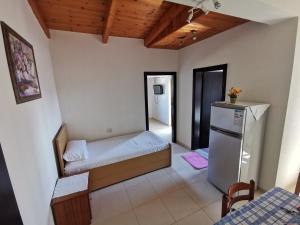 Cette petite chambre comprend un lit et un réfrigérateur. dans l'établissement Ksamil Apartments, à Ksamil