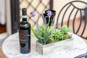 una botella de vino sentada en una mesa con plantas en InternoUno Deluxe en Roma