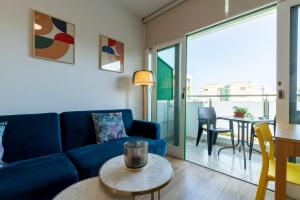 a living room with a blue couch and a table at Trendy, very well located apartment in Playa del Ingles