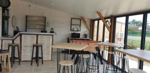 uma cozinha com mesas e bancos num quarto em Le Nichoir em Lion-en-Sullias