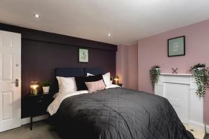 a bedroom with a large bed with purple walls at Brighton Beach 2BR AP with Patio in Brighton & Hove