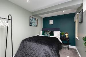 a bedroom with a bed and a blue wall at Brighton Beach 2BR AP with Patio in Brighton & Hove