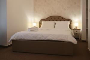 a bedroom with a large bed with two lamps at Perla Sudului - Residence in Timişoara