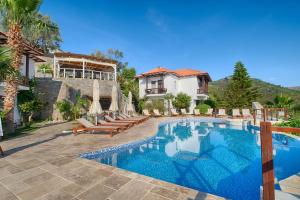 a villa with a swimming pool and a house at Les Terrasses De Selimiye in Selimiye
