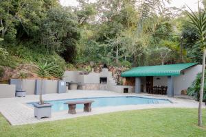 a pool with a picnic table and a bench in a yard at 85 Ehmke Guesthouse in Nelspruit