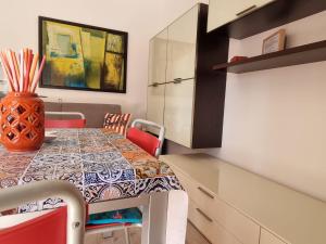 uma sala de jantar com uma mesa com cadeiras e um vaso sobre ela em Sea view apartment with swimming pool em Lido di Jesolo