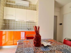 uma cozinha com uma mesa com um vaso sobre ela em Sea view apartment with swimming pool em Lido di Jesolo