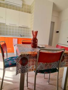 uma mesa de cozinha com duas cadeiras e um vaso sobre ela em Sea view apartment with swimming pool em Lido di Jesolo
