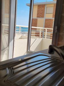 リド・ディ・イエゾロにあるSea view apartment with swimming poolのベッドルームの窓からビーチの景色を望めます。