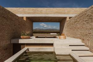 a brick patio with a pond and a bench at Terrestre, a Member of Design Hotels in Puerto Escondido +18 photos