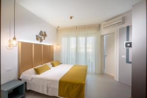 una camera da letto con un grande letto con una coperta gialla di Hotel Marisa a Caorle
