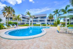 Una piscina con sillas y un edificio. en Mariner Pointe #521, en Sanibel