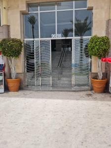 een toegang tot een gebouw met palmbomen in potten bij Mestura Marina Tanger in Tanger