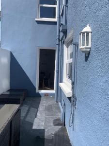 ein blaues Gebäude mit einem Fenster und einer Straßenlaterne in der Unterkunft Perfect base for 8 in Tenby + 33 Fotos