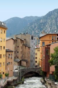 a bridge over a river in a city with buildings at Siracusa in Andorra la Vella