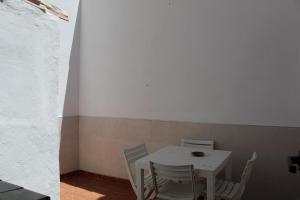 una mesa blanca y sillas en una habitación pequeña en Casa Esmeralda by CasaTuristica, en Ronda 12 fotos más