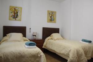 Dos camas una al lado de la otra en una habitación. en Casa Esmeralda by CasaTuristica, en Ronda