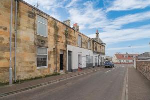 an empty street next to an old brick building at Cosy Ardrossan Apartment in Ardrossan