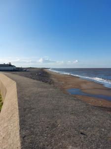 a beach with a retaining wall next to the ocean at 6 berth static caravan, sealands holiday park ingoldmells, skegness in Skegness