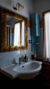 a bathroom with a white sink and a mirror at Villa Assunta in Tertenìa